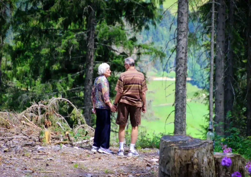Pareja de adultos mayores paseando por la naturaleza para envejecer de forma activa y saludable