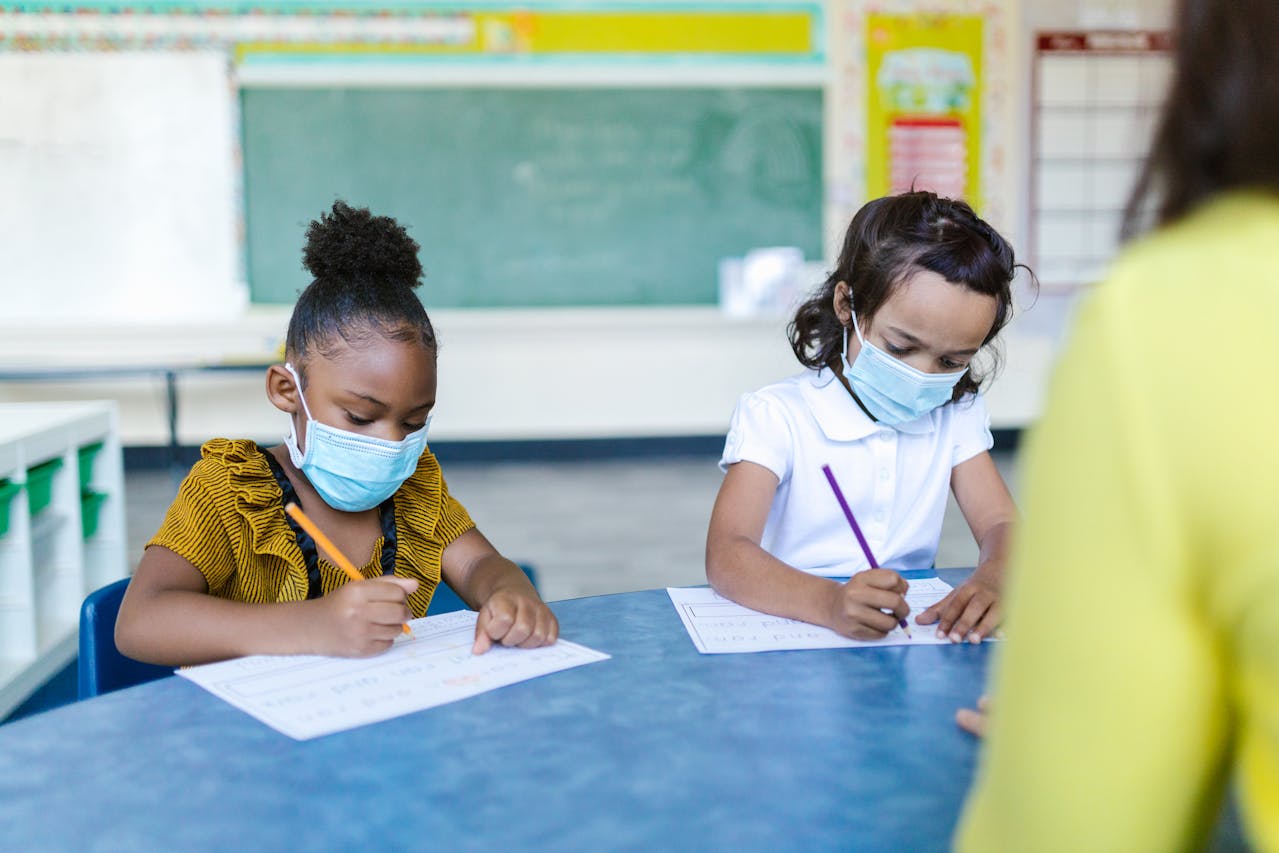 Alumna jóvenes con mascarilla en clase para prevenir contagios