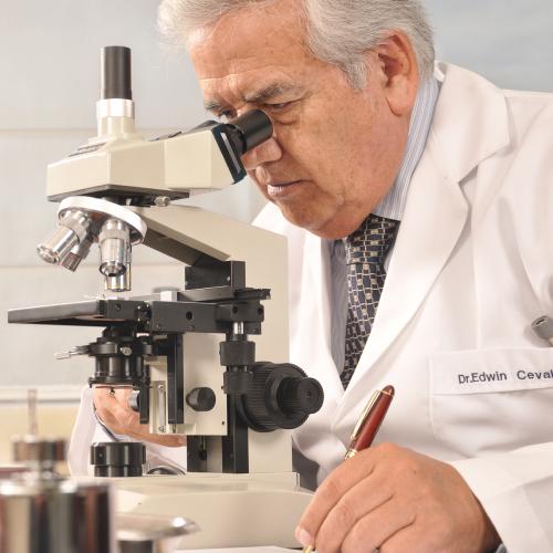 Dr. Edwin Cevallos A. investigando con el microscopio