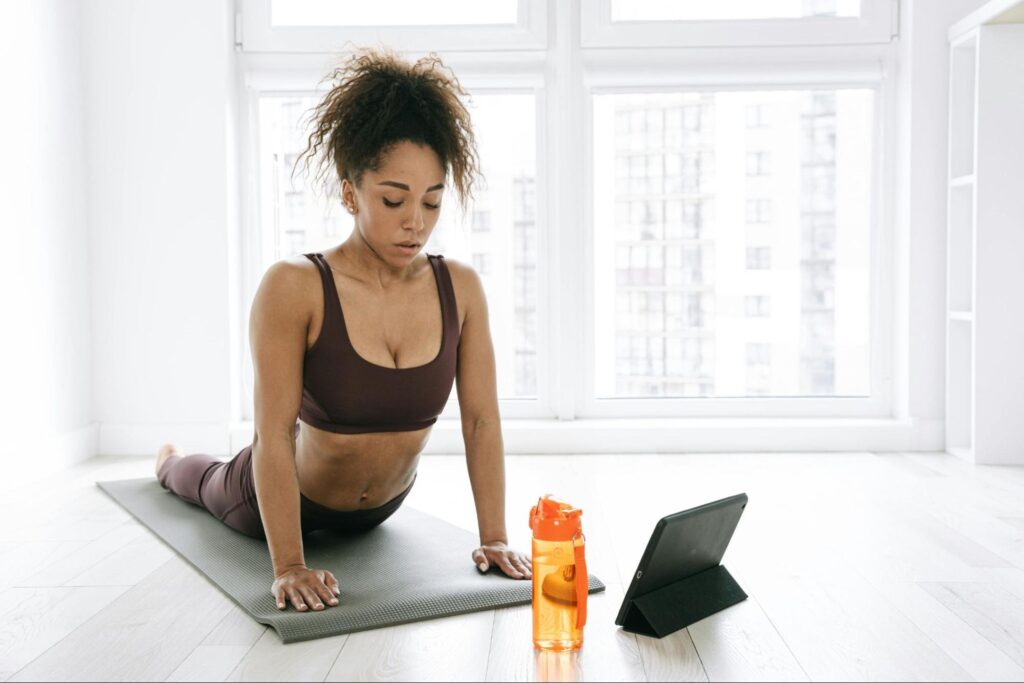 Chica haciendo yoga para desestresar el cuerpo despues de un entrenamiento intenso