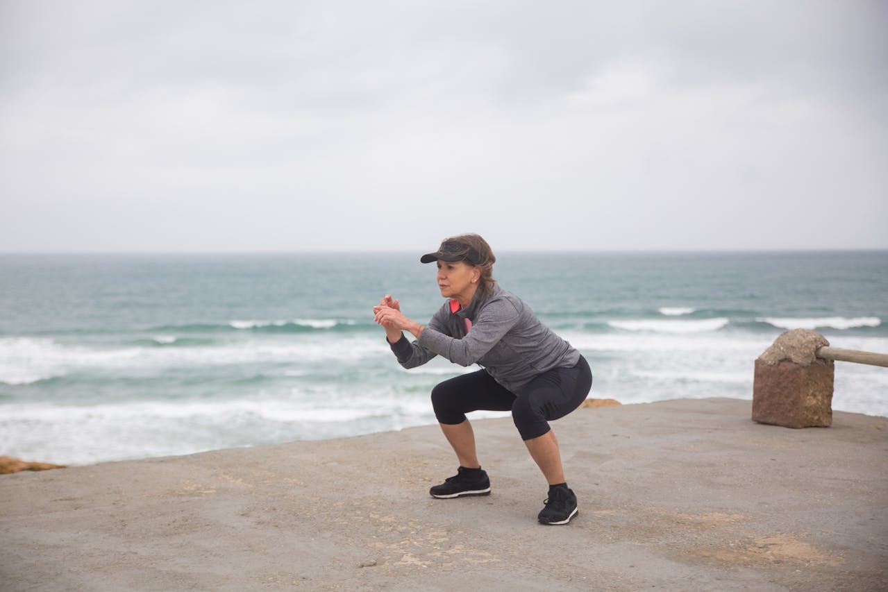 mujer mayor haciendo ejercicio frente al mar