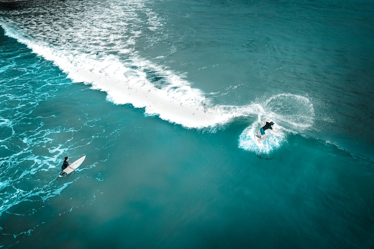 Chicos surfeando después de tomar cacao puro para mejorar su rendimiento deportivo